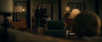 Movie still from “The Adam Project” (2022), directed by Shawn Levy – A woman standing in front of a chair in a living room; Wide shot, Over the shoulder angle