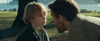 Movie still from “The Adam Project” (2022), directed by Shawn Levy – A man and a boy face each other in a field; Close Up shot, Over the shoulder angle
