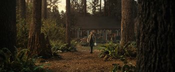 Movie still from “The Adam Project” (2022), directed by Shawn Levy – A man walking down a dirt path in front of a house; Extreme Wide shot, Low angle