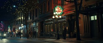 Movie still from “The Adam Project” (2022), directed by Shawn Levy – People are walking on the sidewalk in front of a building; Extreme Wide shot, Over the shoulder angle