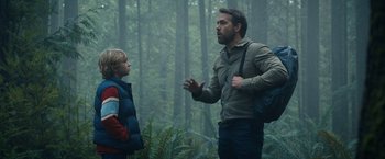 Movie still from “The Adam Project” (2022), directed by Shawn Levy – A man and a boy are talking in the woods; Medium shot, Over the shoulder angle