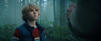 Movie still from “The Adam Project” (2022), directed by Shawn Levy – A young boy in the woods looking up at an adult; Close Up shot, Over the shoulder angle
