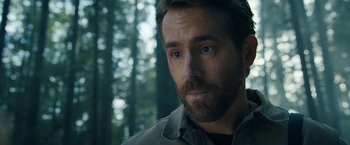 Movie still from “The Adam Project” (2022), directed by Shawn Levy – A person with a beard looking at the camera; Close Up shot, Over the shoulder angle