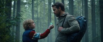 Movie still from “The Adam Project” (2022), directed by Shawn Levy – A man and a boy are looking at each other in the woods; Medium shot, Over the shoulder angle