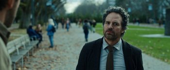 Movie still from “The Adam Project” (2022), directed by Shawn Levy – A man in a suit and tie standing in front of a group of people; Close Up shot, Over the shoulder angle