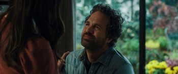 Movie still from “The Adam Project” (2022), directed by Shawn Levy – A man with curly hair and a smirk on his face; Close Up shot, Over the shoulder angle