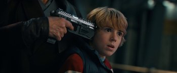 Movie still from “The Adam Project” (2022), directed by Shawn Levy – A young boy holding a gun over his shoulder; Close Up shot, Over the shoulder angle
