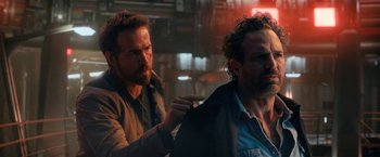 Movie still from “The Adam Project” (2022), directed by Shawn Levy – A man is cutting another man's hair in the dark; Close Up shot, Over the shoulder angle