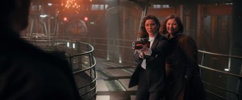 Movie still from “The Adam Project” (2022), directed by Shawn Levy – Two women in business suits are taking a picture; Medium shot, Over the shoulder angle