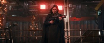 Movie still from “The Adam Project” (2022), directed by Shawn Levy – A woman holding a gun while standing next to a building; Medium shot, Low angle