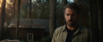 Movie still from “The Adam Project” (2022), directed by Shawn Levy – A person wearing a jacket near a forest; Close Up shot, Over the shoulder angle