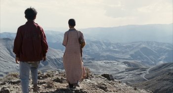 Movie still from “Babel” (2006), directed by Alejandro G. Iñárritu – Two people standing on top of a hill looking out at the mountains; Extreme Wide shot, Low angle