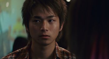 Movie still from “Babel” (2006), directed by Alejandro G. Iñárritu – A man with a plaid shirt is looking at the camera; Close Up shot, Over the shoulder angle