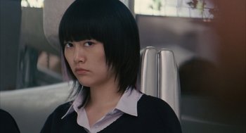 Movie still from “Babel” (2006), directed by Alejandro G. Iñárritu – A woman with a black jacket is sitting down; Close Up shot, Over the shoulder angle