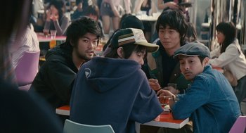 Movie still from “Babel” (2006), directed by Alejandro G. Iñárritu – A group of young men sitting around a table; Medium shot, High angle