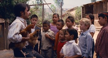 Movie still from “Babel” (2006), directed by Alejandro G. Iñárritu – A group of children standing next to each other with a chicken; Medium shot, High angle