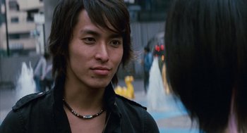 Movie still from “Babel” (2006), directed by Alejandro G. Iñárritu – A young man with long black hair wearing a black jacket; Close Up shot, Over the shoulder angle