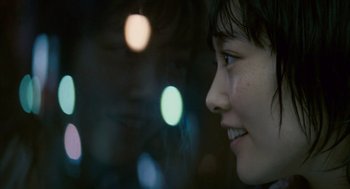 Movie still from “Babel” (2006), directed by Alejandro G. Iñárritu – A woman's face with lights in the background; Close Up shot, Over the shoulder angle