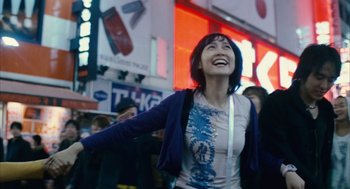 Movie still from “Babel” (2006), directed by Alejandro G. Iñárritu – A woman is standing in a crowd of people; Medium shot, Low angle