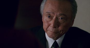 Movie still from “Babel” (2006), directed by Alejandro G. Iñárritu – An older man wearing a suit and tie; Close Up shot, Over the shoulder angle