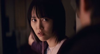 Movie still from “Babel” (2006), directed by Alejandro G. Iñárritu – A young woman with dark hair looking at the camera; Close Up shot, Over the shoulder angle