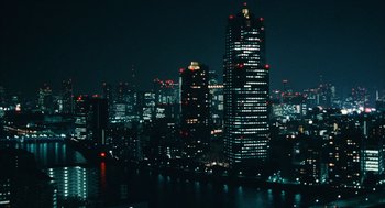Movie still from “Babel” (2006), directed by Alejandro G. Iñárritu – A view of a city at night with lights on buildings; Extreme Wide shot, High angle