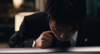 Movie still from “Babel” (2006), directed by Alejandro G. Iñárritu – A person wearing a suit looking down; Extreme Close Up shot, High angle