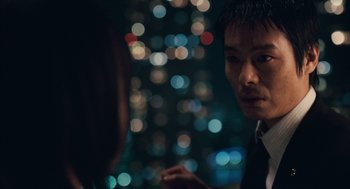 Movie still from “Babel” (2006), directed by Alejandro G. Iñárritu – A man and a woman talking in front of a city skyline at night; Close Up shot, Over the shoulder angle