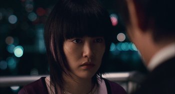 Movie still from “Babel” (2006), directed by Alejandro G. Iñárritu – A young woman with bangs is looking at the camera; Close Up shot, Over the shoulder angle