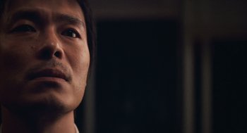 Movie still from “Babel” (2006), directed by Alejandro G. Iñárritu – A man's face in a dark room; Close Up shot, Low angle