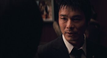 Movie still from “Babel” (2006), directed by Alejandro G. Iñárritu – A person wearing a suit and tie; Close Up shot, Over the shoulder angle