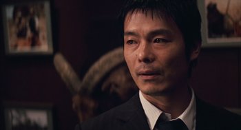 Movie still from “Babel” (2006), directed by Alejandro G. Iñárritu – A person wearing a suit and tie; Close Up shot, Over the shoulder angle