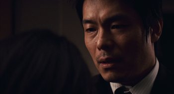 Movie still from “Babel” (2006), directed by Alejandro G. Iñárritu – A person wearing a suit and tie; Close Up shot, Over the shoulder angle