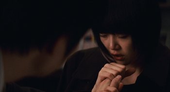Movie still from “Babel” (2006), directed by Alejandro G. Iñárritu – A woman with her hands clasped in front of her face; Close Up shot, Over the shoulder angle