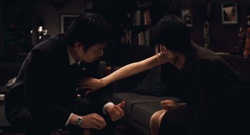 Movie still from “Babel” (2006), directed by Alejandro G. Iñárritu – A man and a woman sitting in a living room; Medium shot, High angle