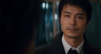 Movie still from “Babel” (2006), directed by Alejandro G. Iñárritu – A person wearing a suit and tie; Close Up shot, Over the shoulder angle