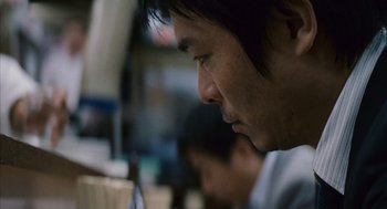 Movie still from “Babel” (2006), directed by Alejandro G. Iñárritu – A person looking at a computer screen; Close Up shot, Low angle