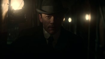 Movie still from “The Alienist” (2018), created by Cary Joji Fukunaga – A man wearing a suit and a hat in the dark; Close Up shot, Low angle