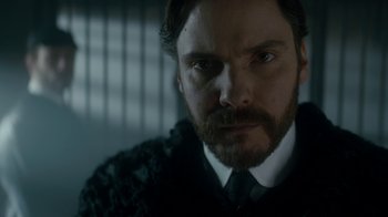 Movie still from “The Alienist” (2018), created by Cary Joji Fukunaga – A person wearing a suit and tie; Close Up shot, Low angle