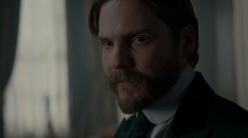 Movie still from “The Alienist” (2018), created by Cary Joji Fukunaga – A person wearing a suit and tie; Close Up shot, Over the shoulder angle