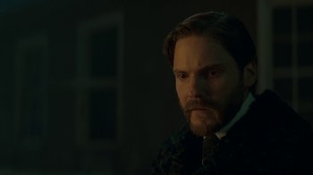 Movie still from “The Alienist” (2018), created by Cary Joji Fukunaga – A man with a beard wearing a suit and tie; Close Up shot, Over the shoulder angle