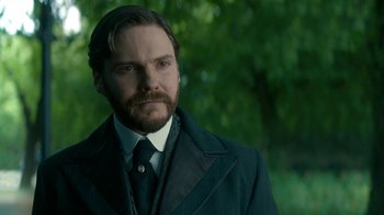 Movie still from “The Alienist” (2018), created by Cary Joji Fukunaga – A person wearing a suit and tie; Close Up shot, Over the shoulder angle
