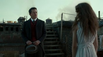 Movie still from “The Alienist” (2018), created by Cary Joji Fukunaga – A man and a woman standing next to each other; Medium shot, Over the shoulder angle