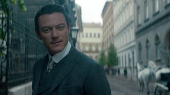 Movie still from “The Alienist” (2018), created by Cary Joji Fukunaga – A person wearing a suit and tie; Close Up shot, Over the shoulder angle