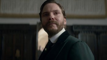 Movie still from “The Alienist” (2018), created by Cary Joji Fukunaga – A person wearing a suit and tie; Close Up shot, Low angle