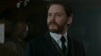 Movie still from “The Alienist” (2018), created by Cary Joji Fukunaga – A man in a suit and tie looking to his left; Close Up shot, Low angle