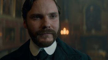 Movie still from “The Alienist” (2018), created by Cary Joji Fukunaga – A person wearing a suit and tie; Close Up shot, Over the shoulder angle