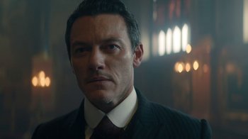 Movie still from “The Alienist” (2018), created by Cary Joji Fukunaga – A person wearing a suit and tie; Close Up shot, Over the shoulder angle