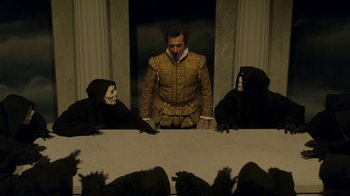 Movie still from “The Alienist” (2018), created by Cary Joji Fukunaga – A group of people sitting at a table with a man in a costume; Medium shot, High angle