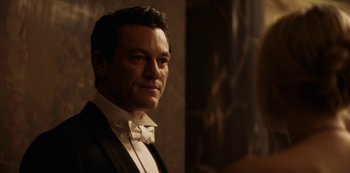 Movie still from “The Alienist” (2018), created by Cary Joji Fukunaga – A person wearing a suit and bow tie; Close Up shot, Over the shoulder angle